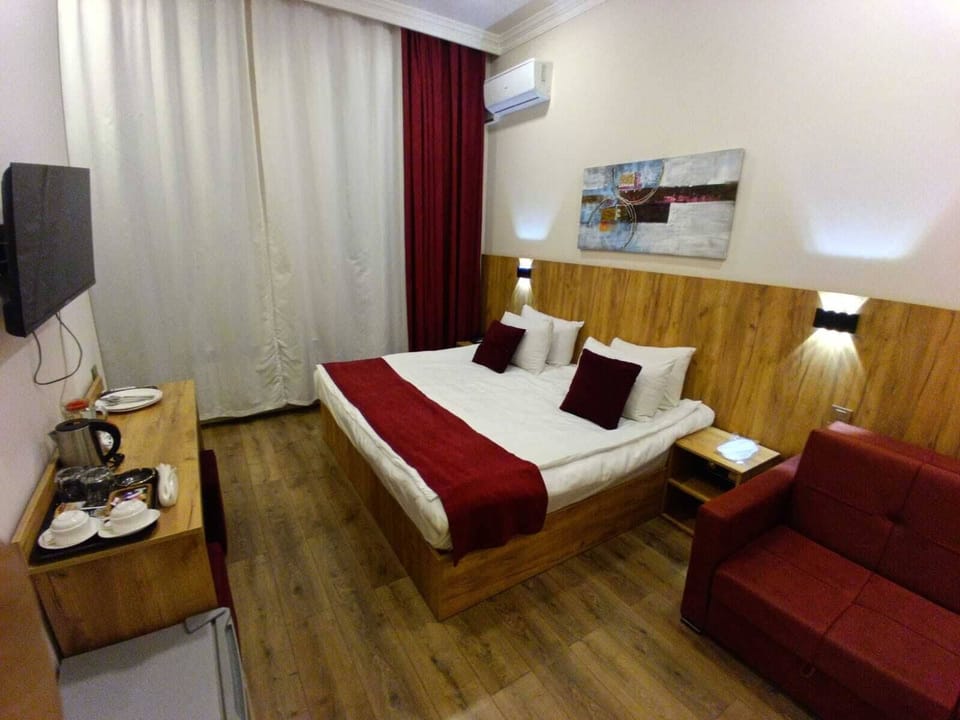 Family Triple Room, Balcony, City View | In-room safe, desk, laptop workspace, blackout drapes