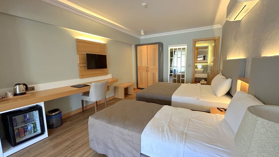 Superior Triple Room, Multiple Beds | Minibar, in-room safe, desk, laptop workspace