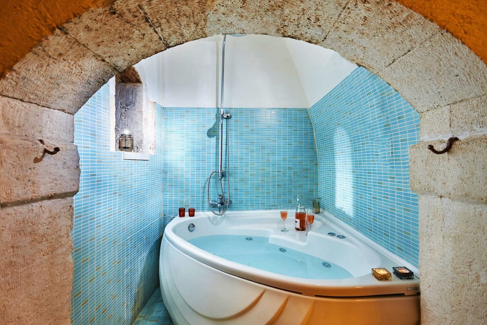 Deluxe Suite, 1 Queen Bed, Hot Tub | Bathroom | Hair dryer, towels, soap, shampoo