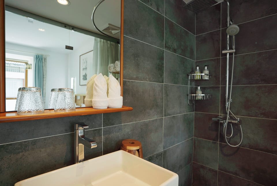 Separate tub and shower, hair dryer, slippers, towels