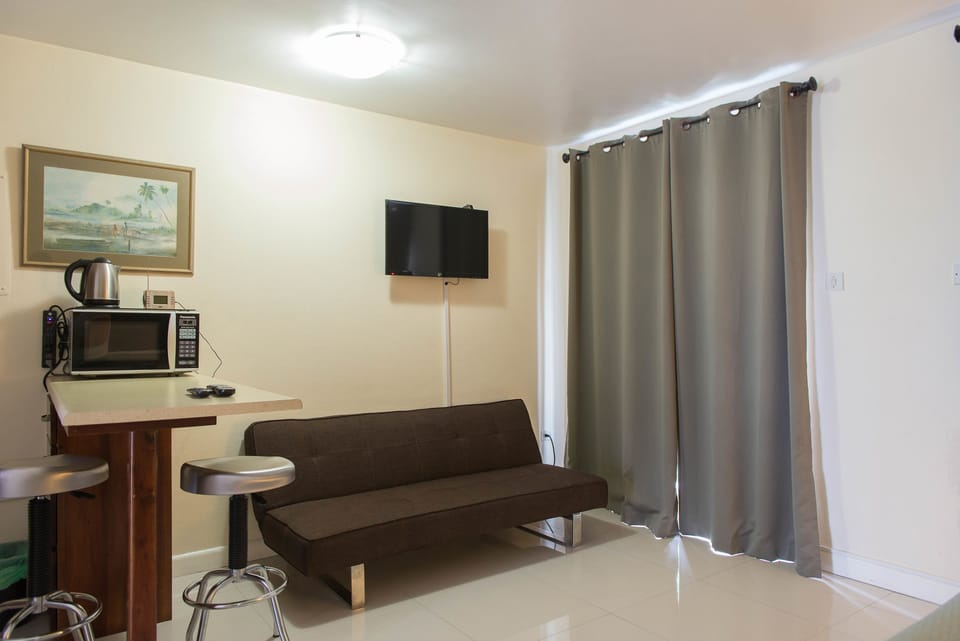 Deluxe Studio, 1 King Bed, Beachside | Living room | Flat-screen TV