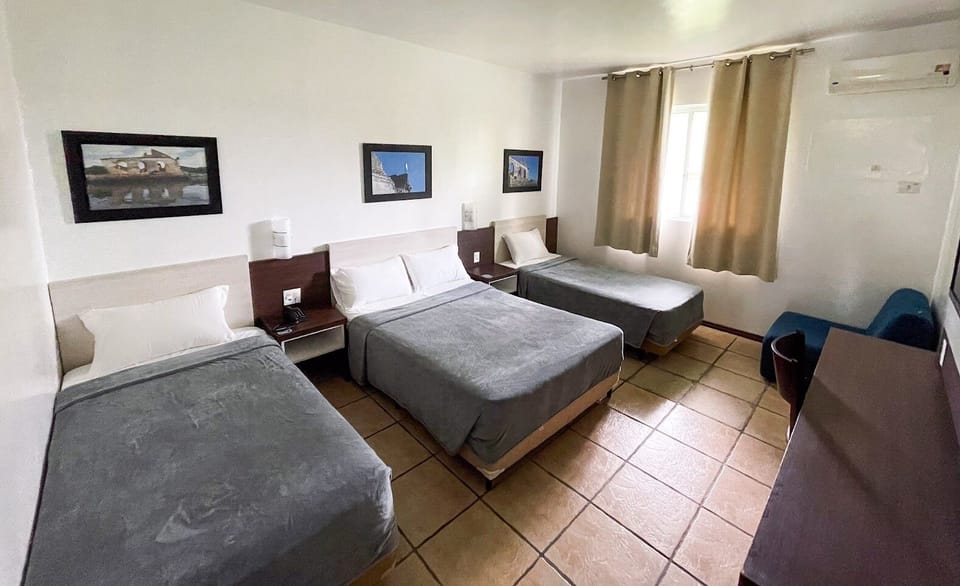 Triple Room, Garden View | Minibar, in-room safe, individually decorated, desk