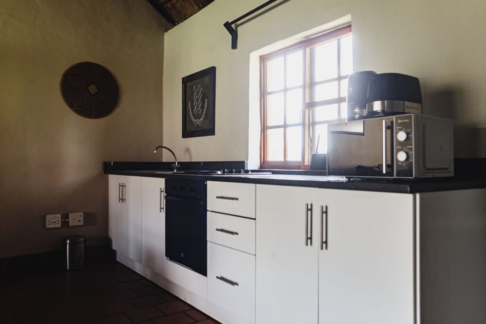 Executive Cottage | Private kitchen | Electric kettle, cleaning supplies