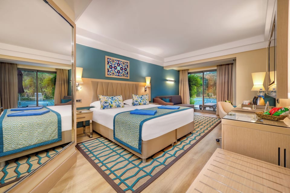Deluxe Suite, Poolside | Minibar, in-room safe, desk, free cribs/infant beds