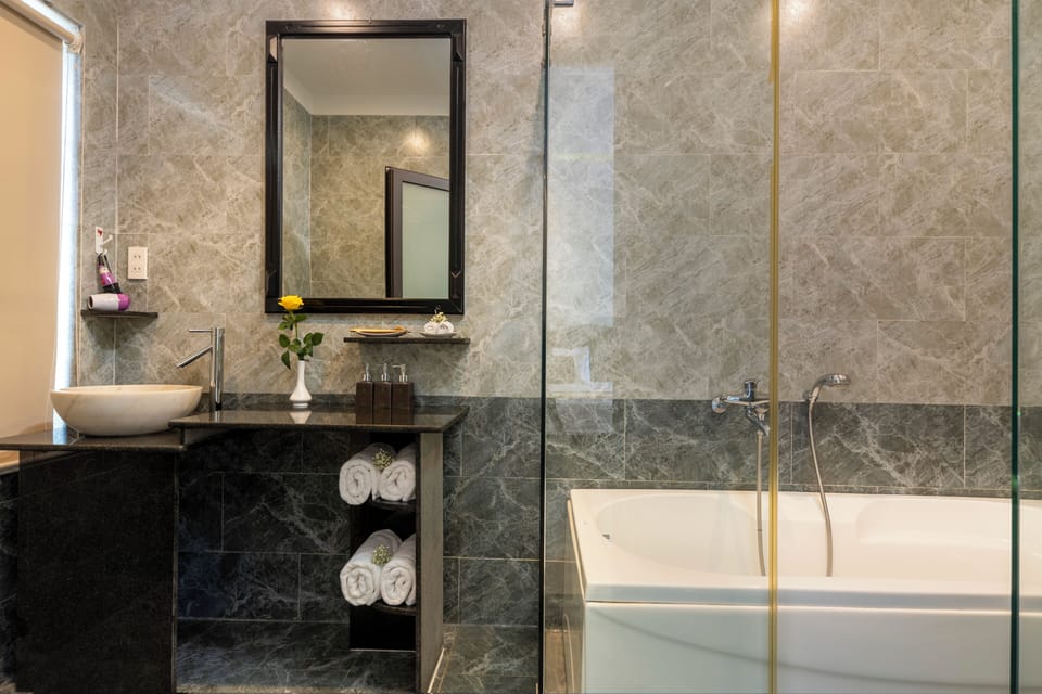 Deluxe Room | Bathroom | Separate tub and shower, designer toiletries, hair dryer, slippers