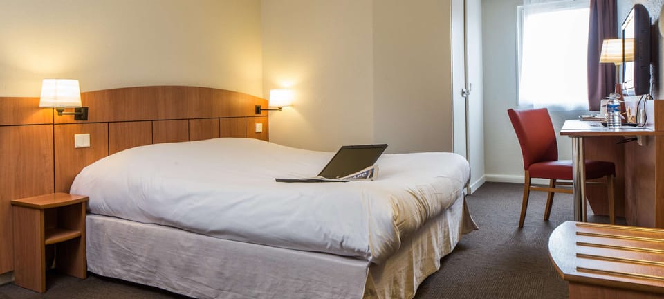 Premium bedding, desk, laptop workspace, blackout drapes
