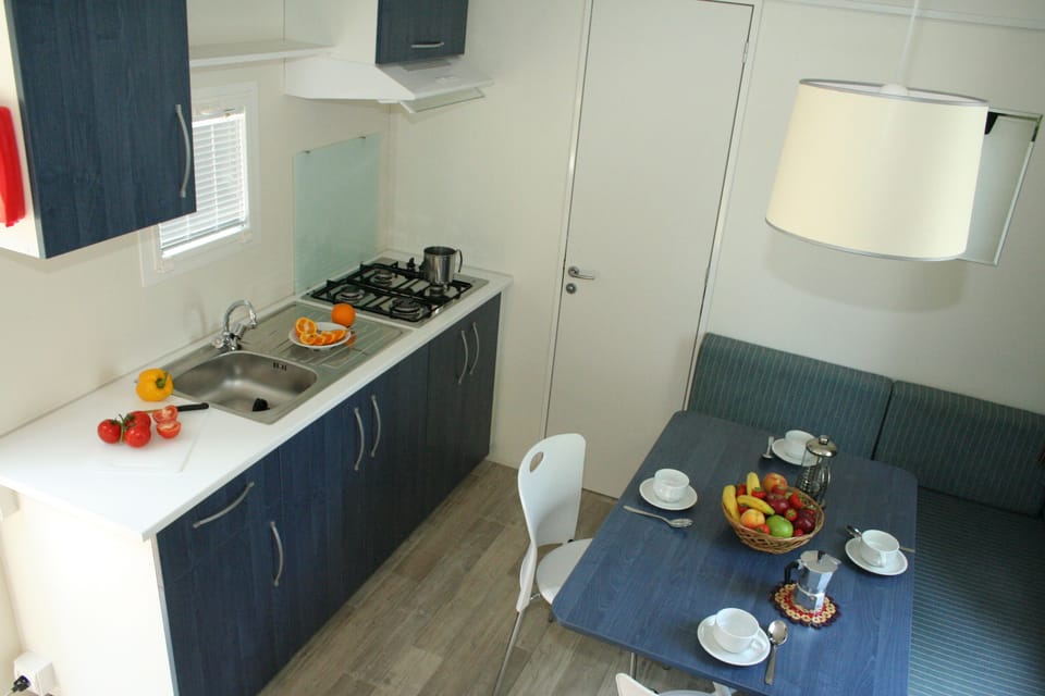 Full-size fridge, stovetop, cookware/dishes/utensils, dining tables