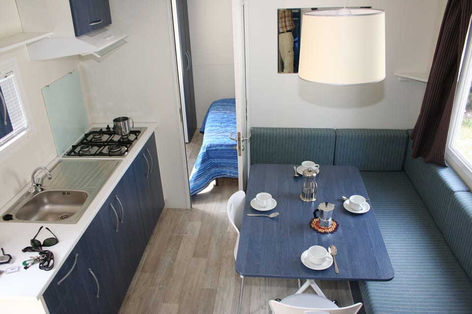 Full-size fridge, stovetop, cookware/dishes/utensils, dining tables