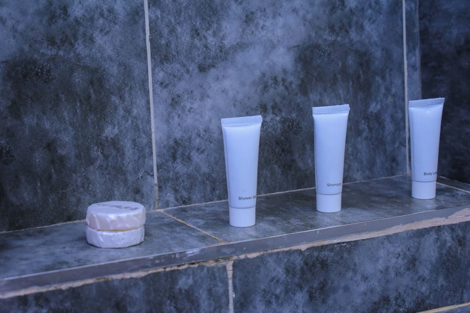 Shower, designer toiletries, slippers, towels