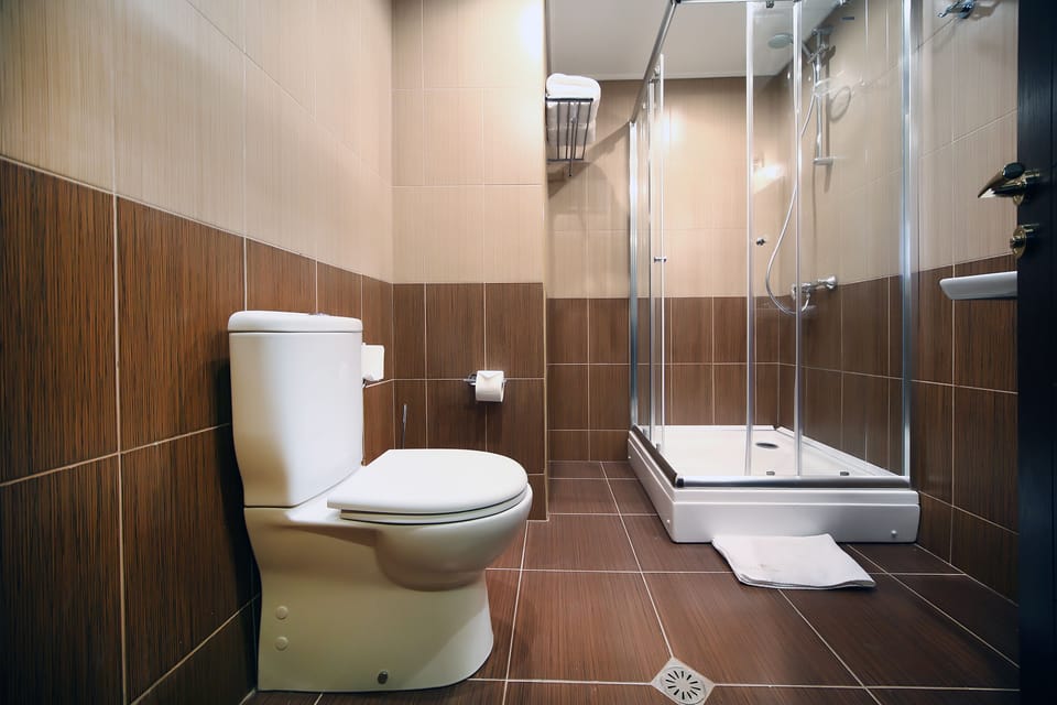Deluxe Room | Bathroom | Shower, hair dryer, bathrobes, slippers