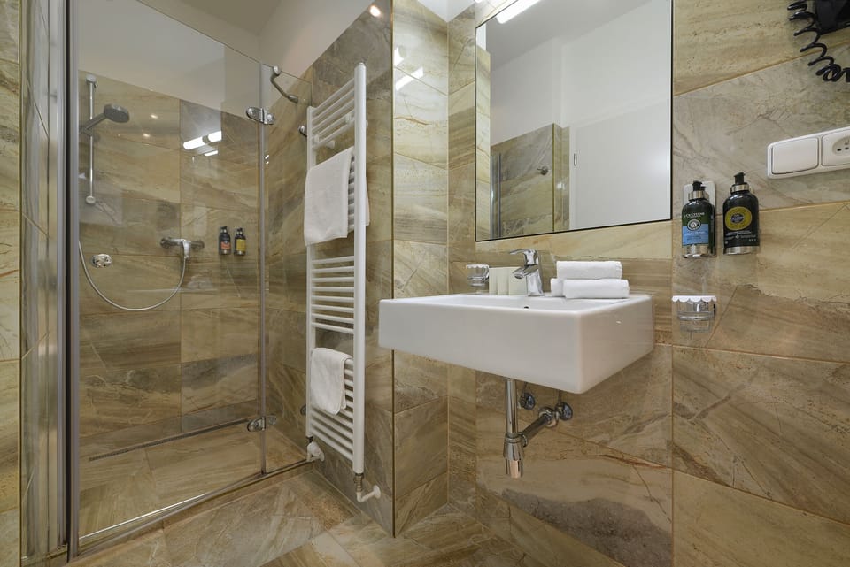 Shower, designer toiletries, slippers, towels