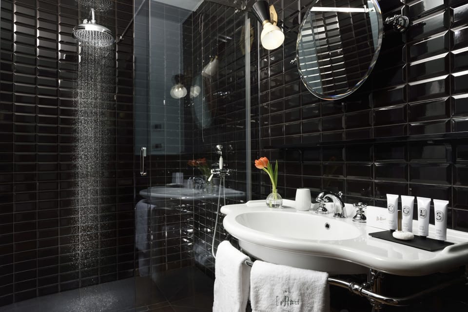 Shower, designer toiletries, slippers, towels