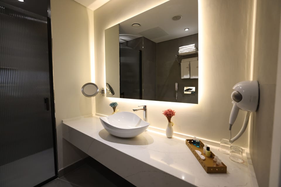 Deep soaking tub, rainfall showerhead, designer toiletries, hair dryer