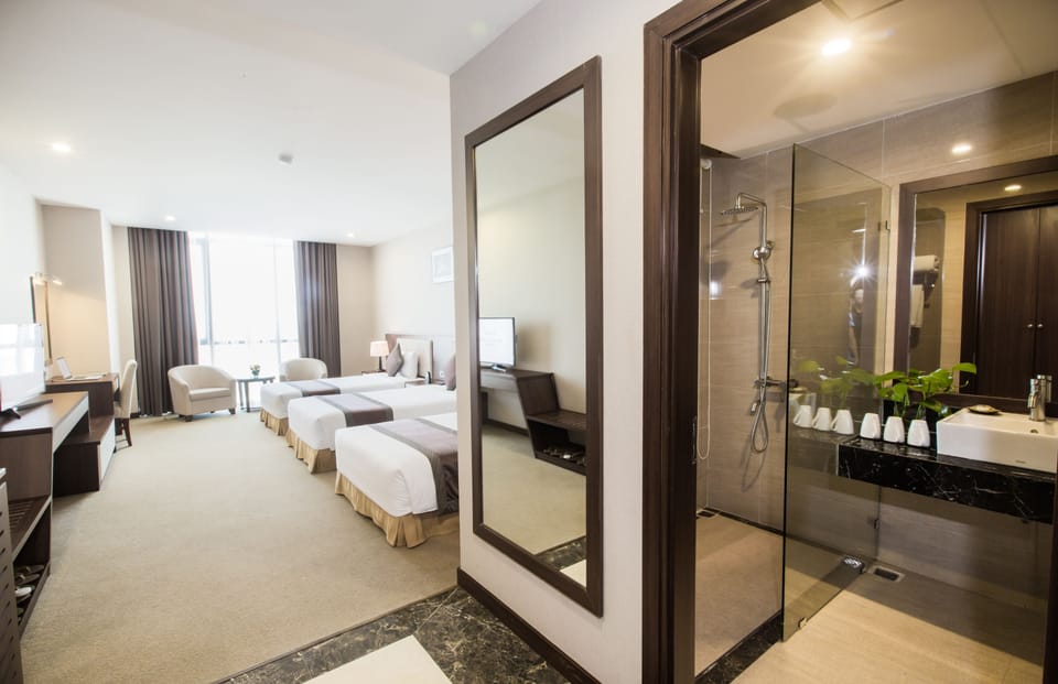 Deluxe Triple Room | Minibar, in-room safe, desk, blackout drapes