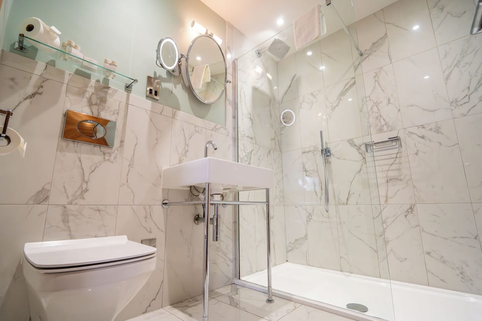 Deluxe Suite | Bathroom | Shower, designer toiletries, slippers, towels