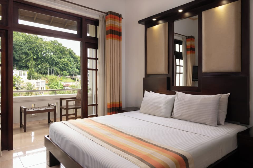 Deluxe Room | Minibar, in-room safe, desk, iron/ironing board