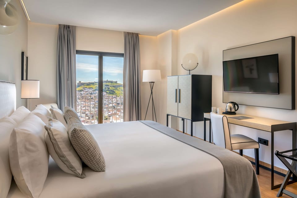 Deluxe Room, Pool View | Minibar, in-room safe, desk, laptop workspace