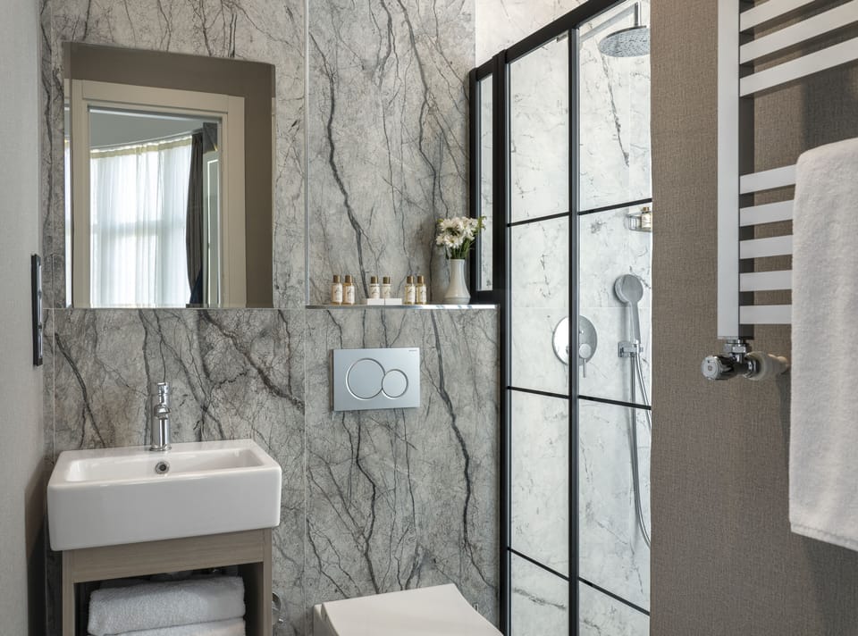 Shower, designer toiletries, hair dryer, slippers