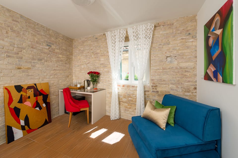 City Triple Room | Living area | 140-cm flat-screen TV with cable channels, TV