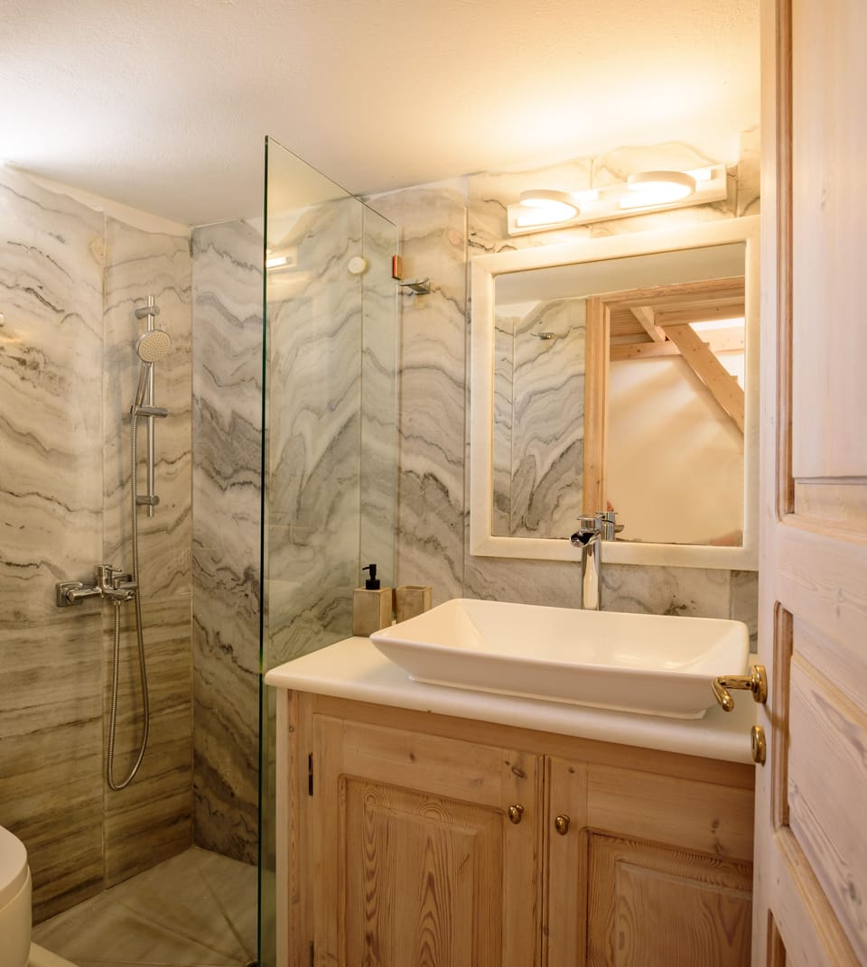 Executive Maisonette Cave Suite - Caldera Sea view & Pool view | Bathroom | Combined shower/tub, rainfall showerhead, free toiletries, hair dryer
