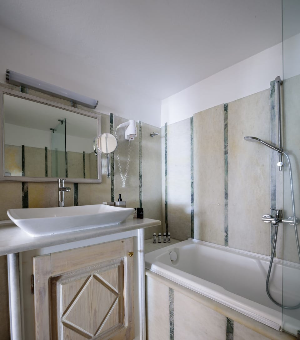 Superior Cave Suite - Caldera Sea View | Bathroom | Combined shower/tub, rainfall showerhead, free toiletries, hair dryer