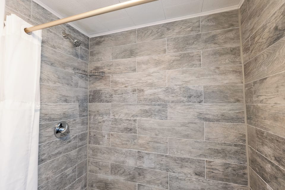 Deluxe Queen | Bathroom | Combined shower/tub, towels, soap, shampoo