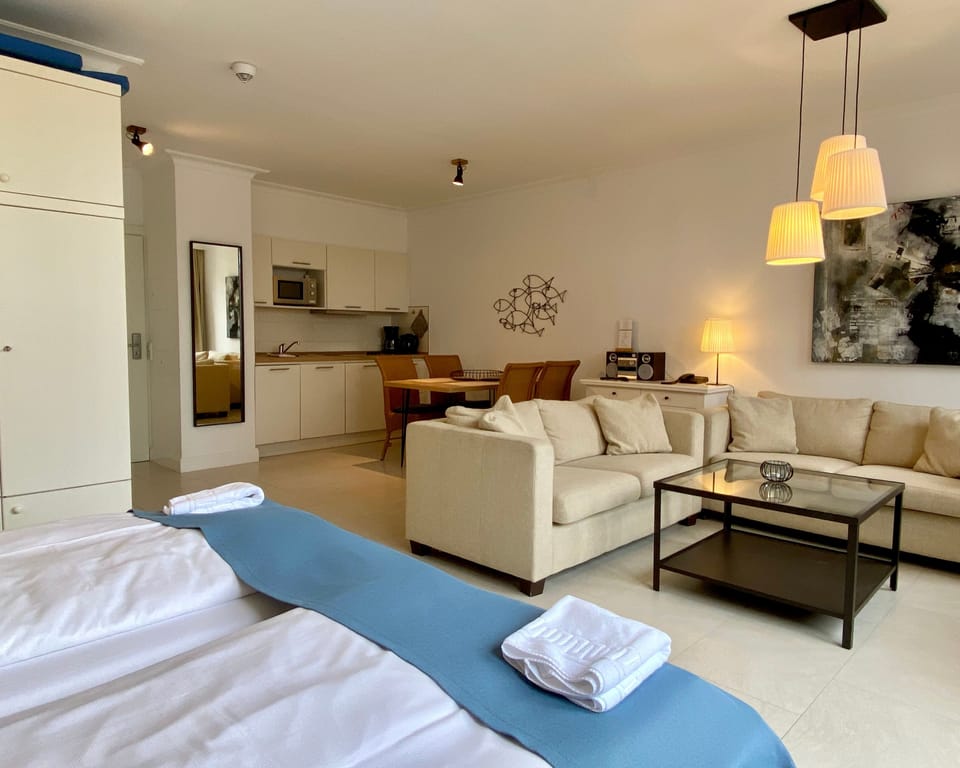 Studio mit Balkon | Living area | Flat-screen TV