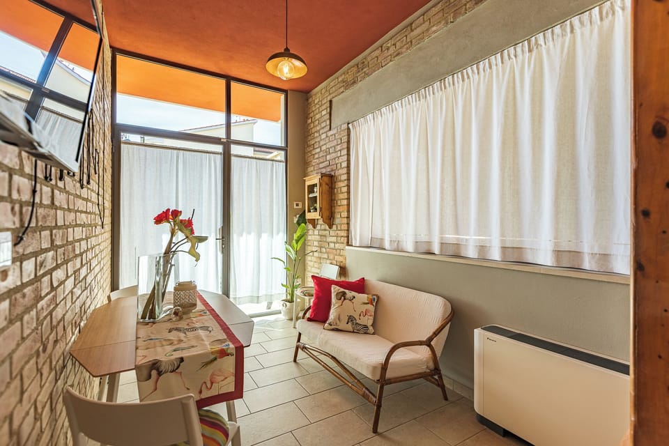 Deluxe Room, Garden View (c) | Living area | Flat-screen TV, books