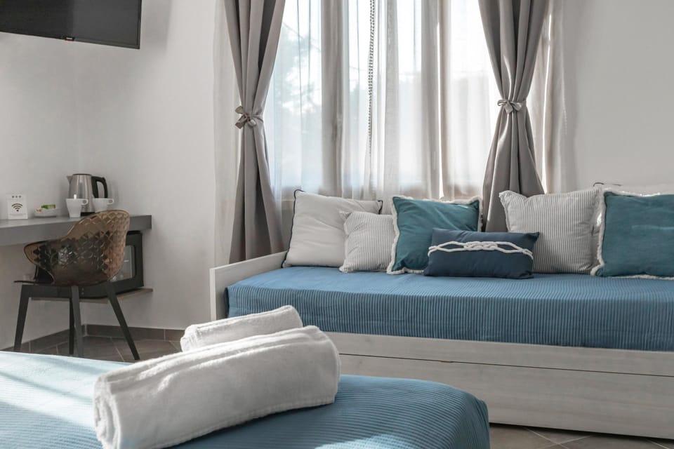 Deluxe Quadruple Room | Minibar, in-room safe, desk, blackout drapes