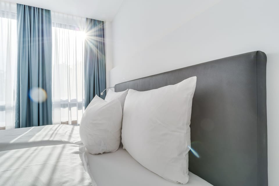Hypo-allergenic bedding, desk, laptop workspace, blackout drapes