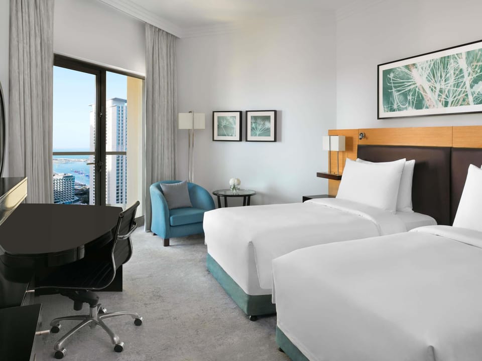 Deluxe Twin Room, Balcony, Partial Sea View | Minibar, in-room safe, desk, laptop workspace