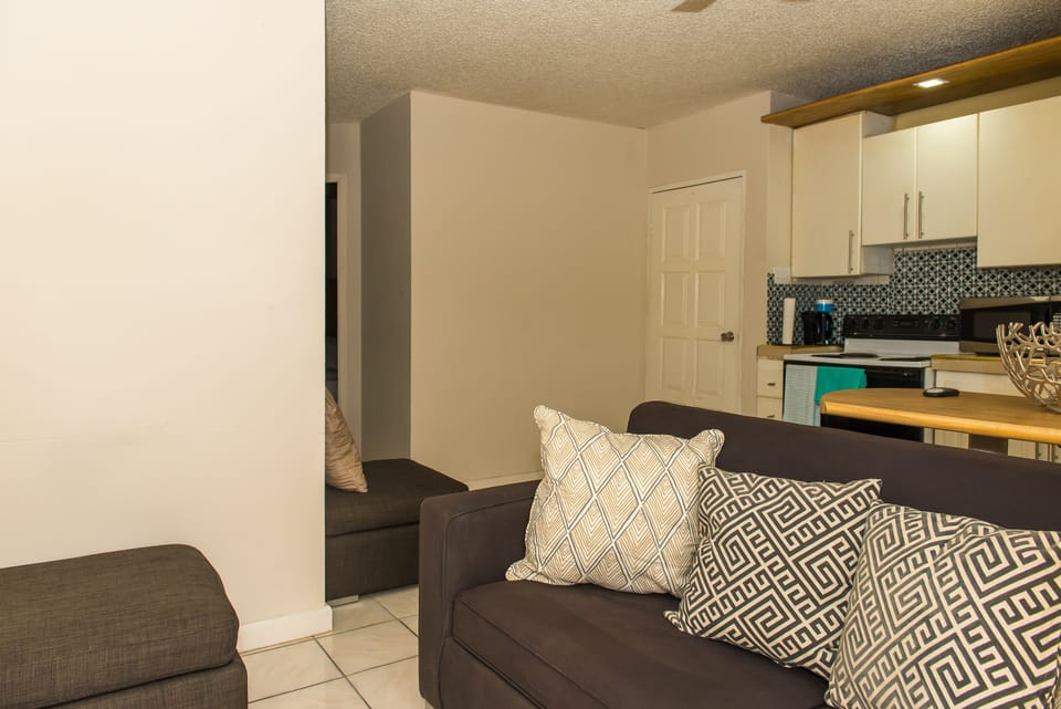 Business Apartment, Pool View | Living area | 50-inch flat-screen TV with cable channels, TV, DVD player