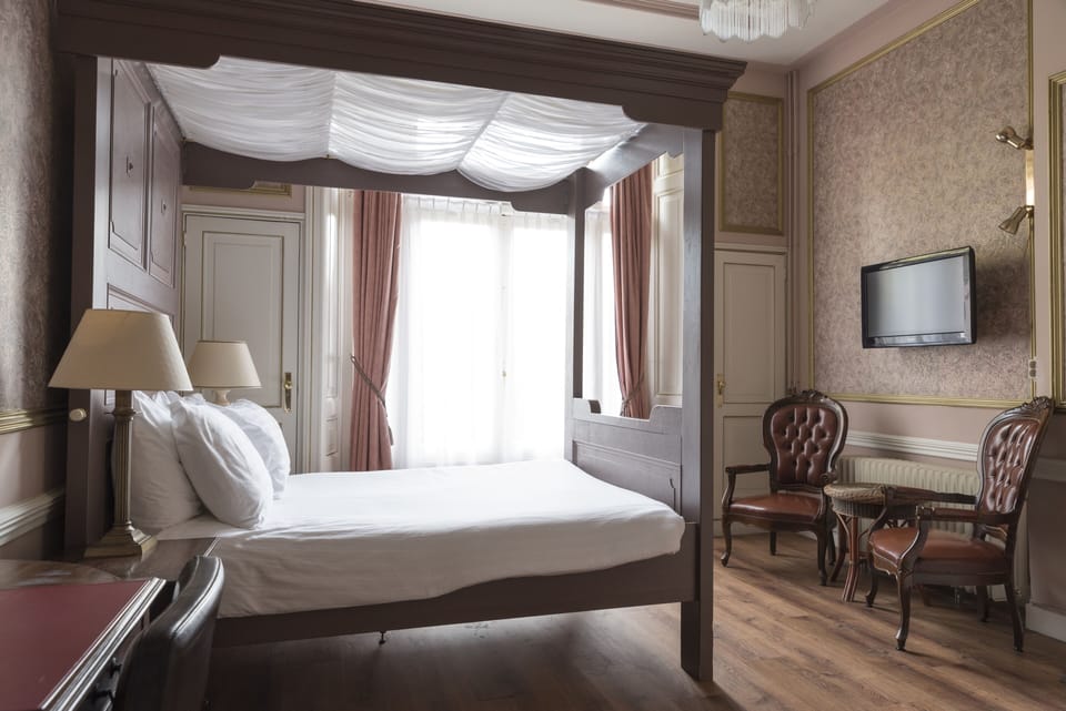 Comfort room with four-poster bed | In-room safe, individually furnished, desk, iron/ironing board