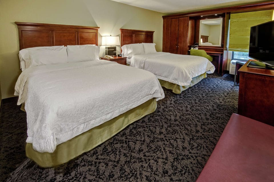 Hypo-allergenic bedding, desk, laptop workspace, blackout drapes