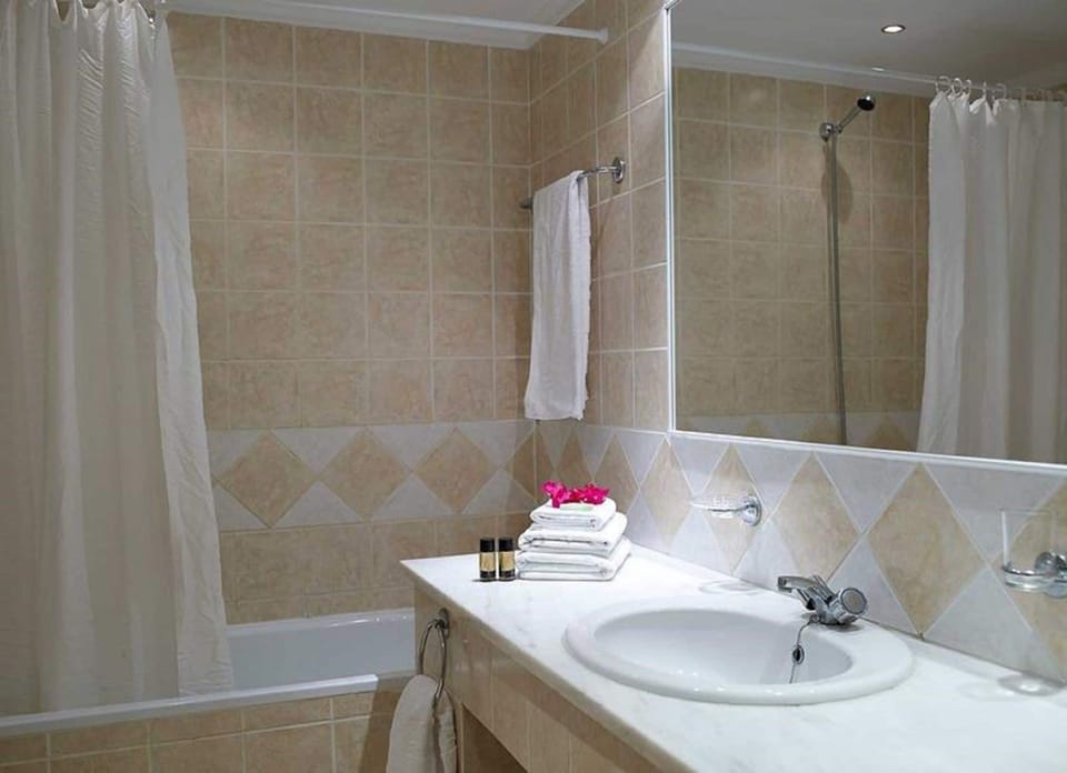 Bathtub, hair dryer, slippers, towels