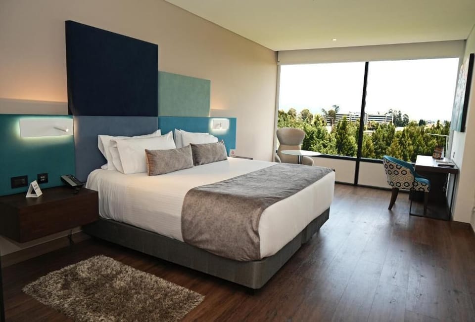 Deluxe Room | Minibar, in-room safe, desk, blackout drapes