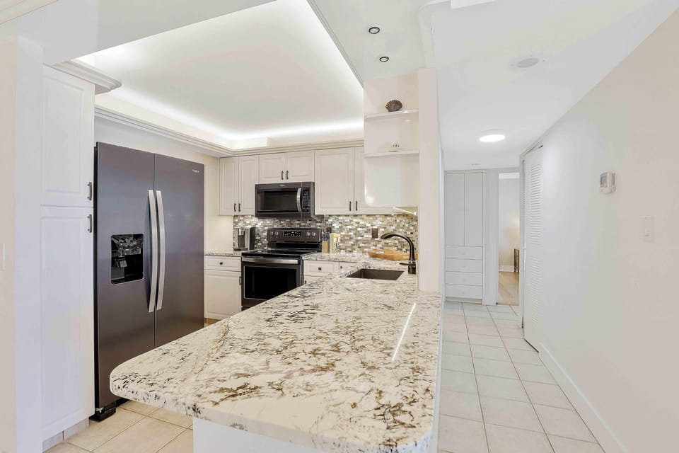 Condo, Multiple Beds (Alluring beachfront condo with pool a) | Private kitchen | Fridge, microwave, oven, stovetop