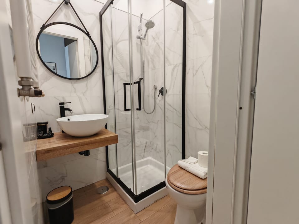 Triple Room (Yellow) | Bathroom | Shower, hair dryer, slippers, towels