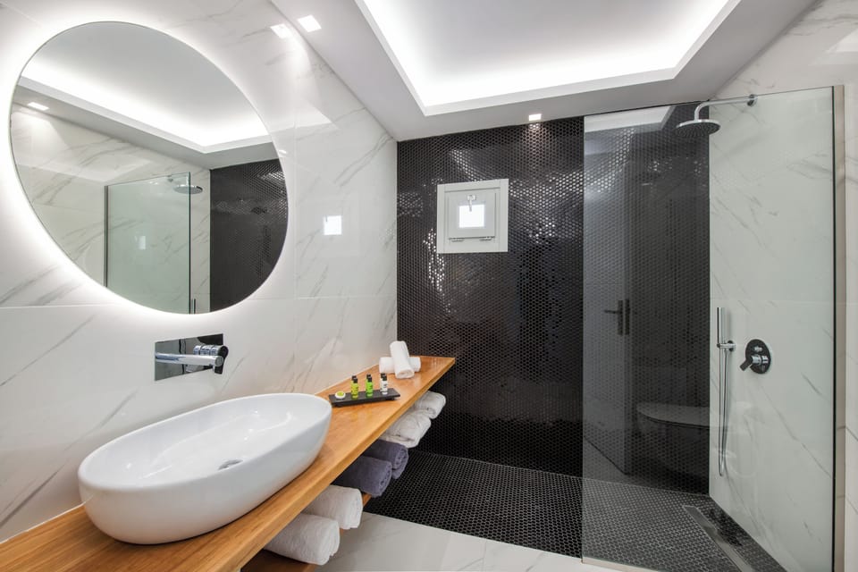 Deluxe Suite | Bathroom | Combined shower/tub, rainfall showerhead, designer toiletries