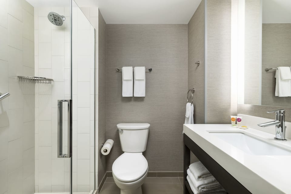 Shower, designer toiletries, hair dryer, towels