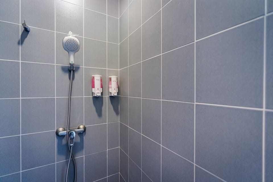 Deluxe Room, 1 Queen Bed | Bathroom | Shower, hair dryer, slippers, towels