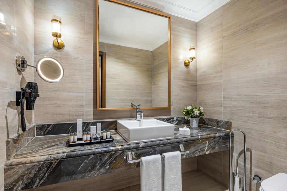 Deluxe Room, City View | Bathroom | Designer toiletries, hair dryer, bathrobes, slippers