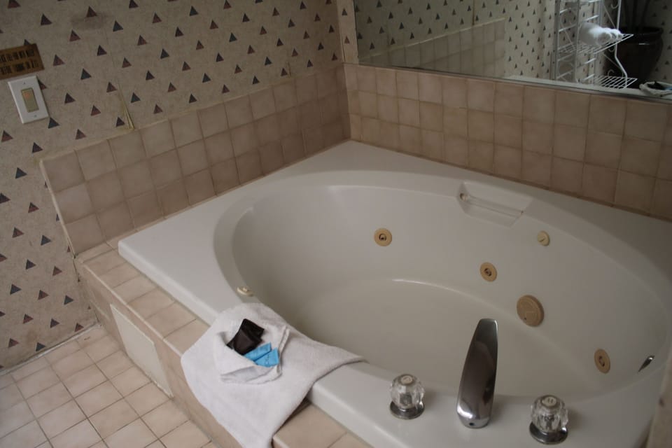 Luxury Suite, Jacuzzi | Bathroom | Combined shower/tub, deep soaking tub, free toiletries, hair dryer