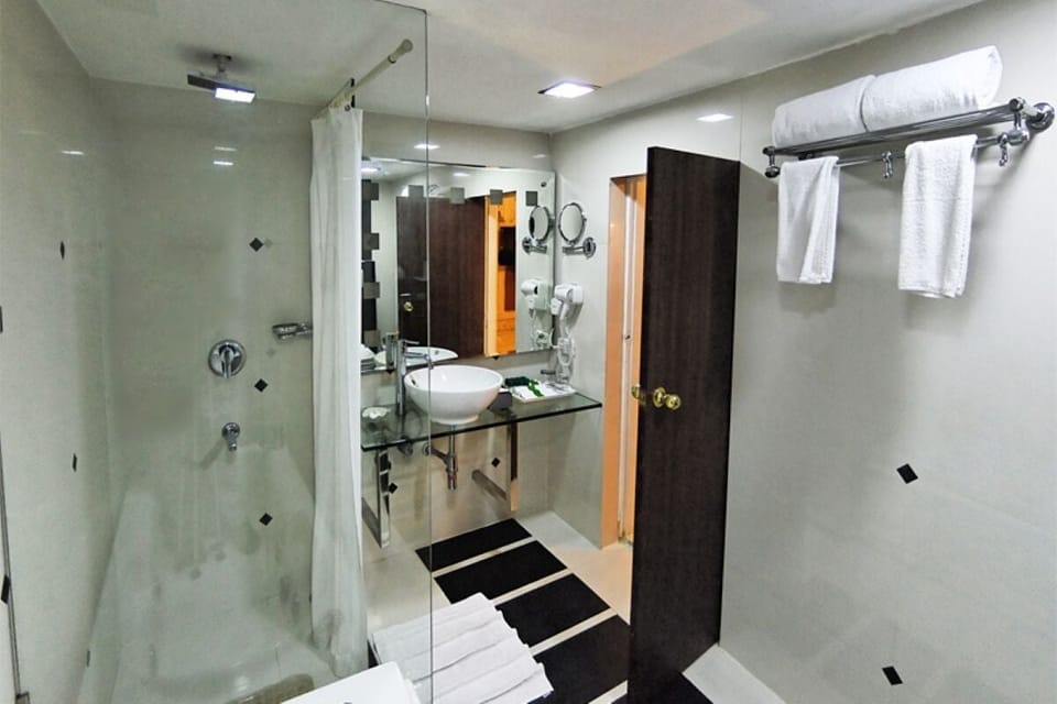 Deluxe Single Room, 1 King Bed | Bathroom | Combined shower/tub, free toiletries, hair dryer, slippers