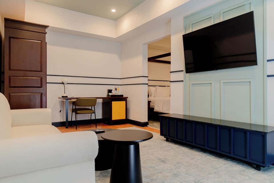 Suite, 1 Queen Bed | Living area | 32-inch plasma TV with cable channels, TV, first-run movies