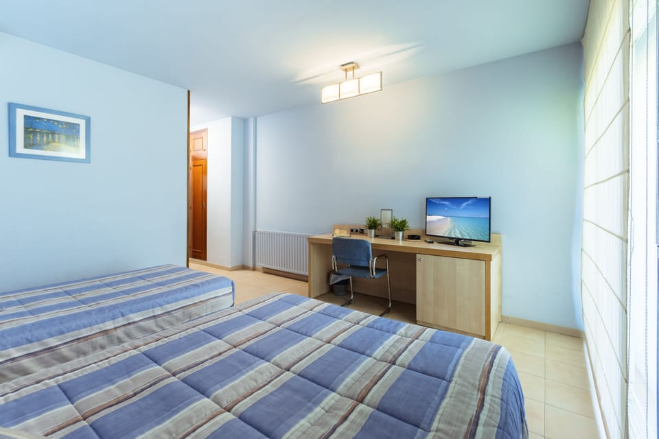 Family Triple Room | Down comforters, desk, laptop workspace, blackout drapes