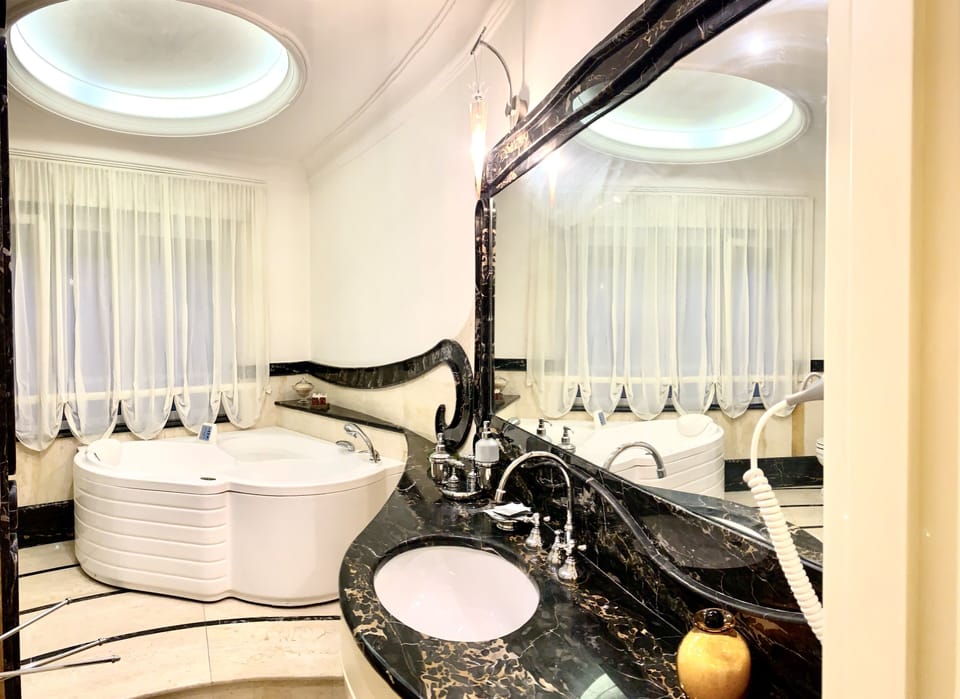 Deluxe Suite, Jetted Tub | Bathroom | Hair dryer, towels, soap, shampoo