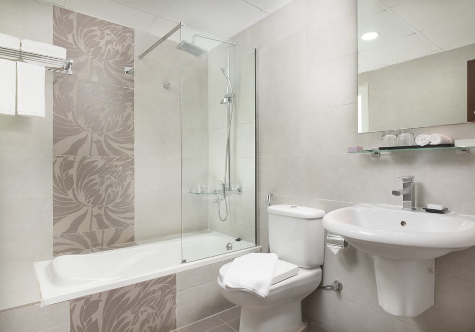 Deluxe Suite, 1 King Bed | Bathroom | Shower, hair dryer, towels