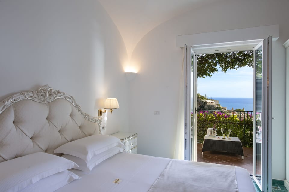 Deluxe Suite, Sea View | Minibar, in-room safe, individually decorated, desk