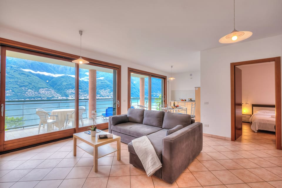 Family Apartment, 1 Bedroom, Microwave, Mountainside (Va Pensiero sul lago Stunning View) | Living area | 21-inch flat-screen TV with digital channels, TV, offices